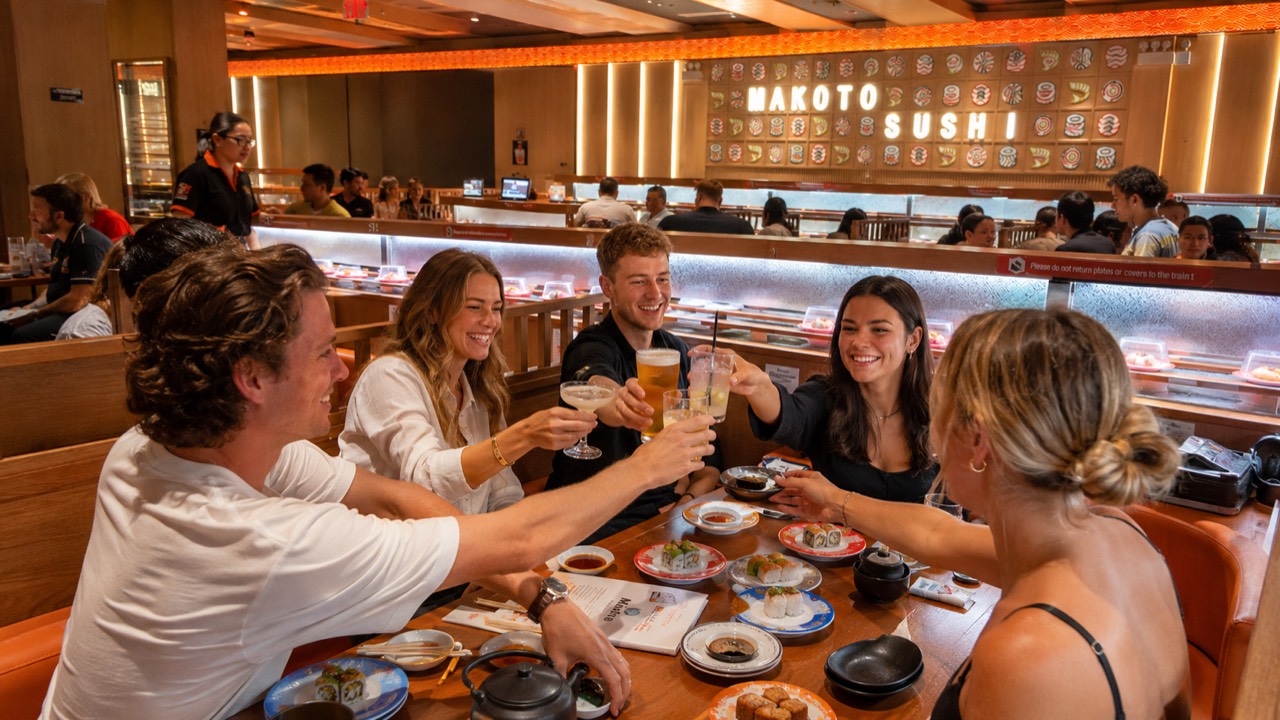 Cheers — celebrating over sushi at Makoto Friends toasting drinks together over sushi at Makoto revolving sushi bar in Staten Island