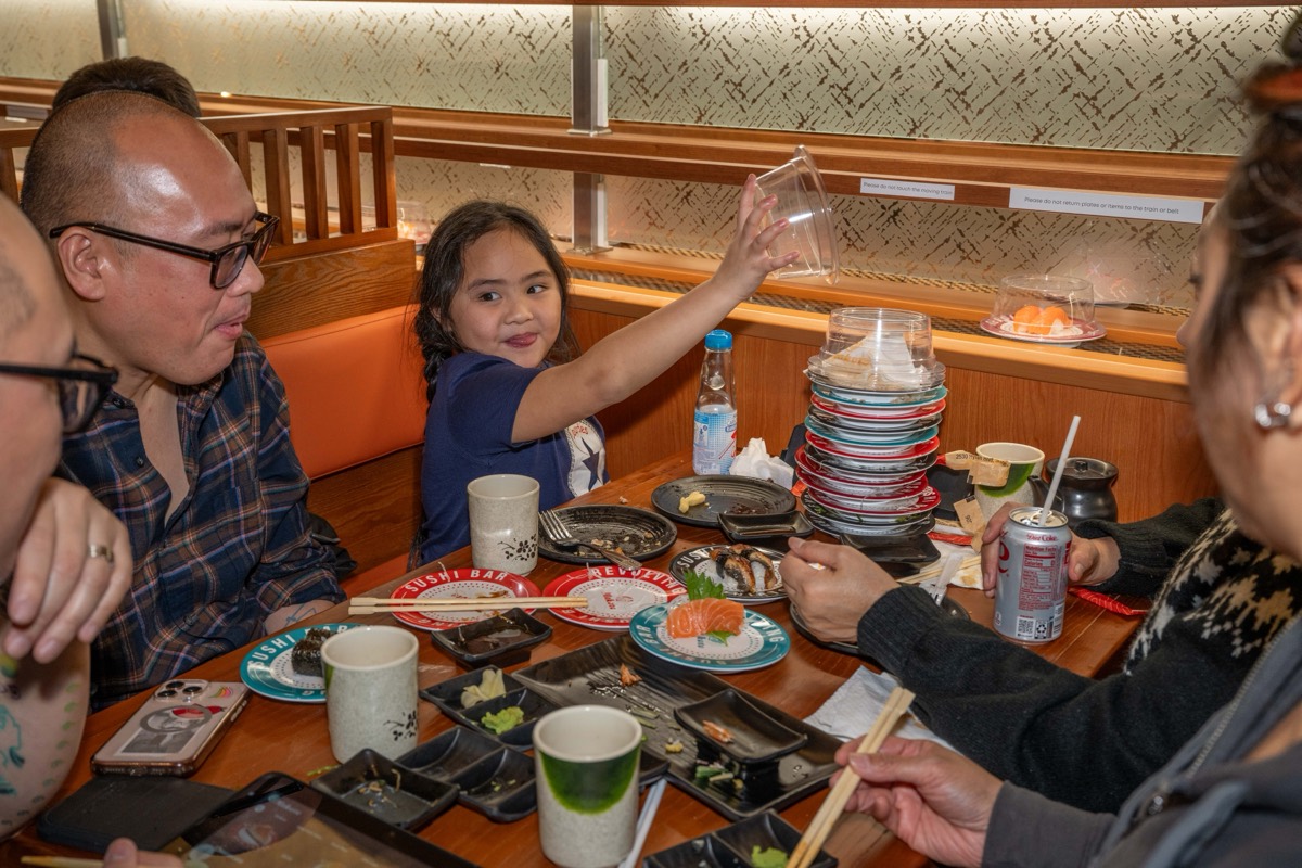 Aavya Bargas, 6, takes a dish from the conveyor belt at Makoto Revolving Sushi in New Dorp, Staten Island