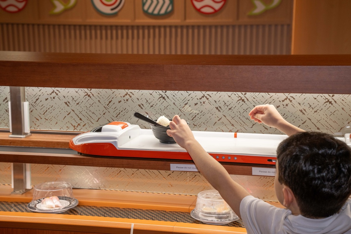 Sonny DiBlasi, 8, reaches for a dish on the train at Makoto Revolving Sushi in New Dorp, Staten Island