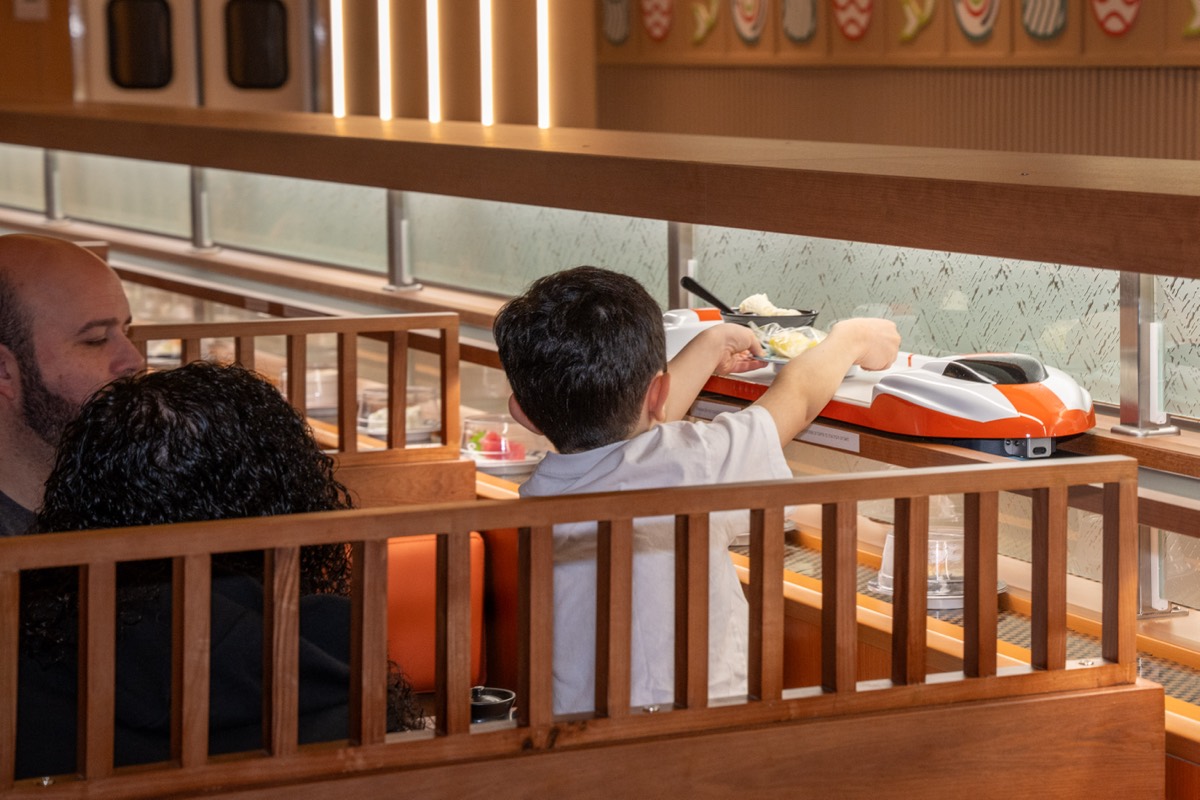 Sonny DiBlasi, 8, takes a dish from the train at Makoto Revolving Sushi in New Dorp, Staten Island