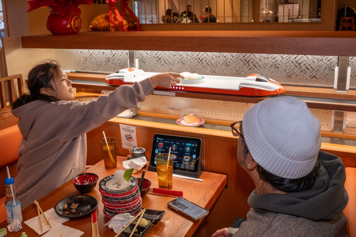 Ellie Gapud, 11, has her food delivered by train at Makoto Revolving Sushi Bar in New Dorp, Staten Island