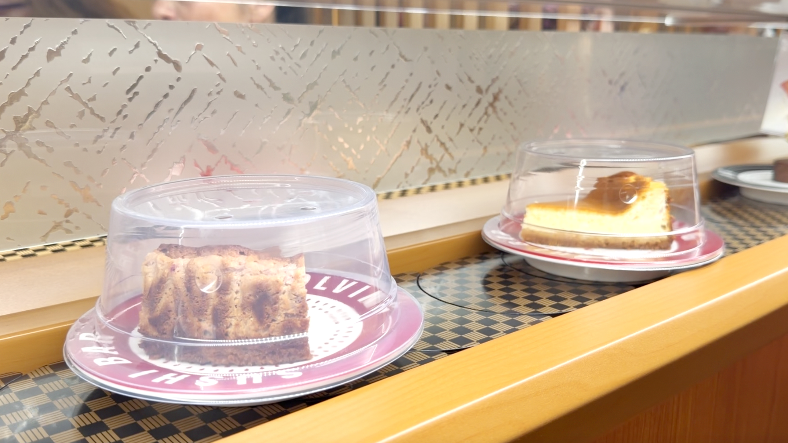 Belt-side desserts at Makoto House cake square and basque cheesecake desserts rolling on the belt at Makoto Staten Island