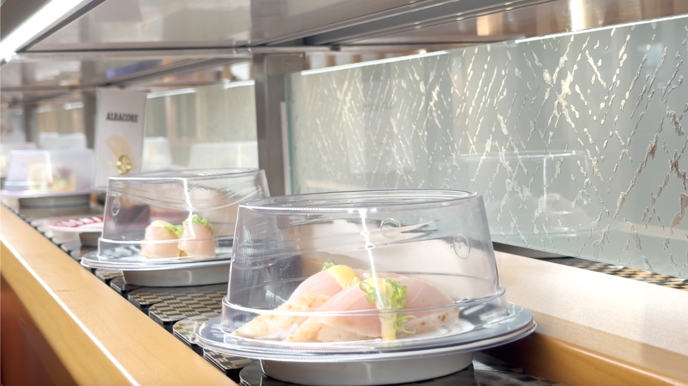 Albacore nigiri on the belt Albacore nigiri plates rolling on the conveyor belt at Makoto Staten Island
