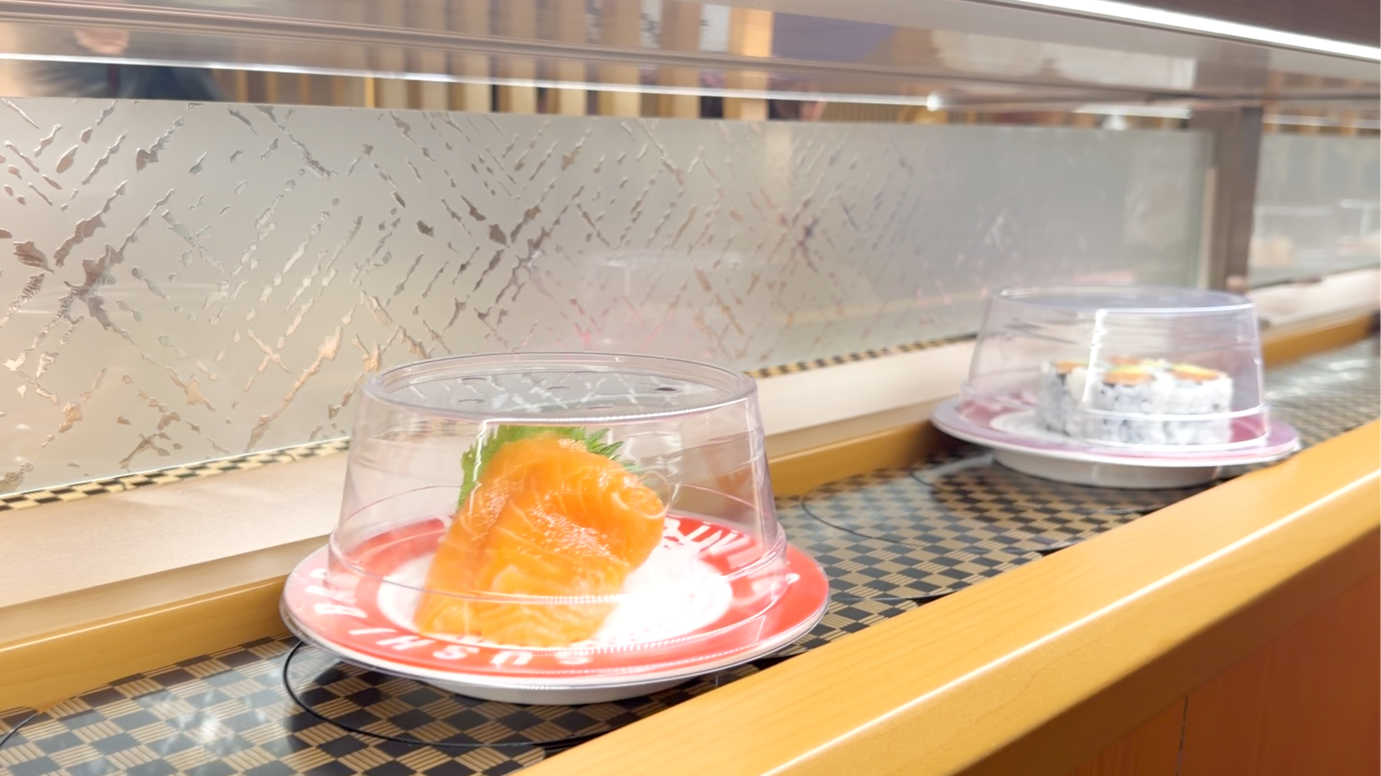 Salmon sashimi off the belt Fresh salmon sashimi plate rolling on the conveyor belt at Makoto Staten Island