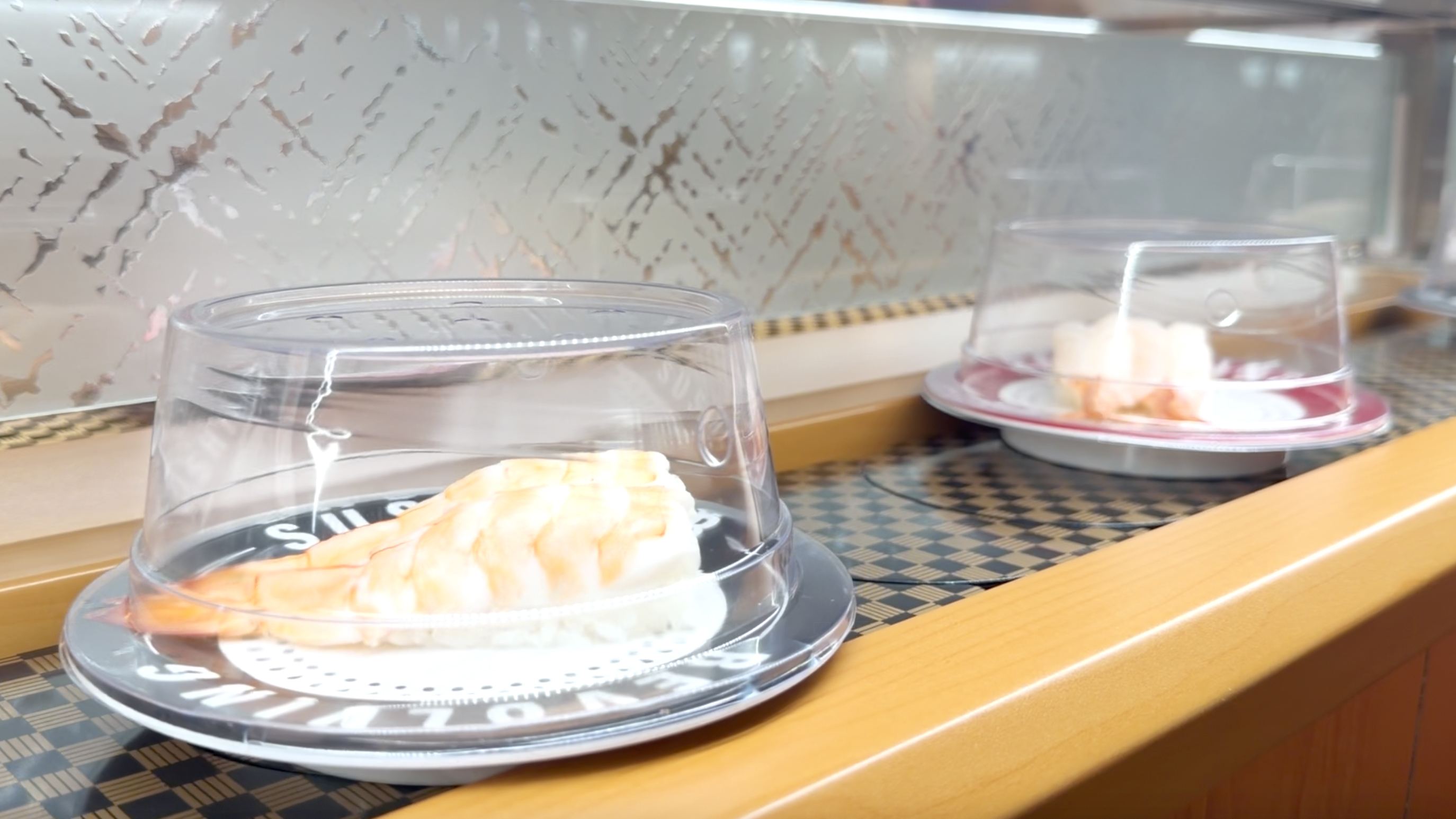 Ebi shrimp nigiri on the belt Butterflied shrimp nigiri rolling past on the belt at Makoto Staten Island